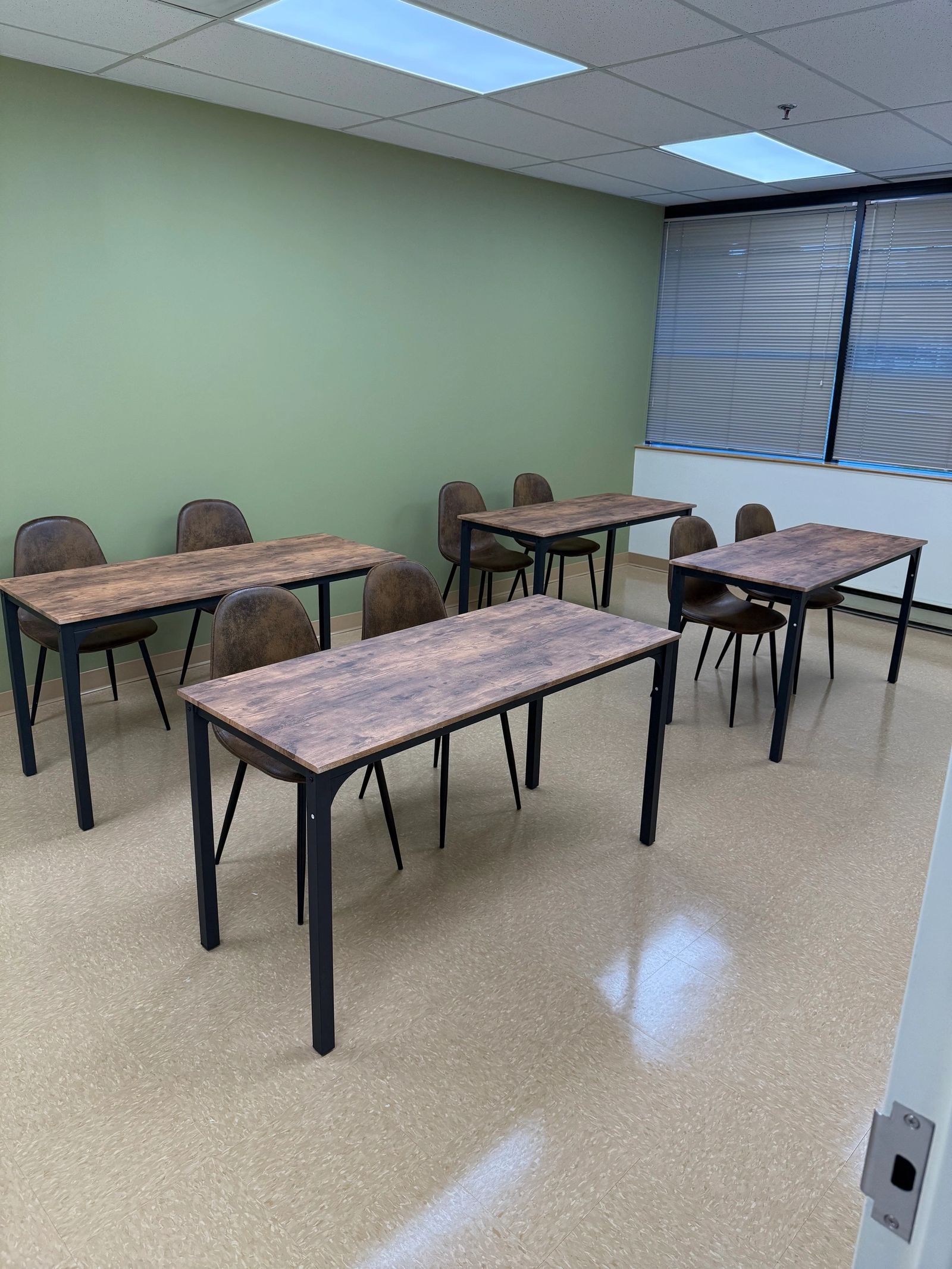 Professional training room with tables, chairs and natural light at The Self Care Sanctuary Suites in Laurel, Maryland